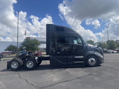 Volvo VNL64T660 tractor unit side view showing sleeper cab and chrome wheels with six tires, black paint, no visible text.
