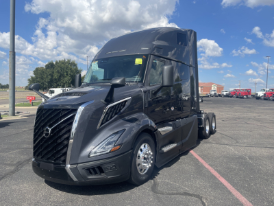 Volvo VNL64T660 truck in a dealership lot, black exterior, cab with large sleeper, front grille and headlights visible.