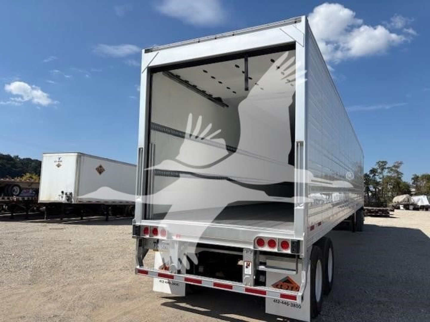 Rear of a Vanguard R8000B trailer with open rear doors, showing empty loading area and dual rear axles.