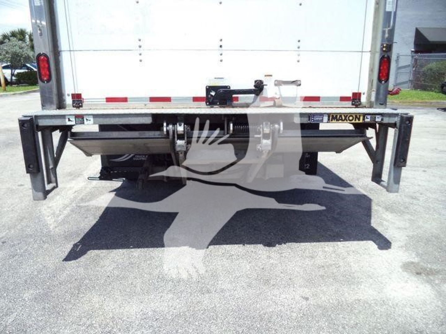 Isuzu NPR HD box truck rear view showing bumper, undercarriage, and Maxon/metal framework, with taillights and reflective tape.