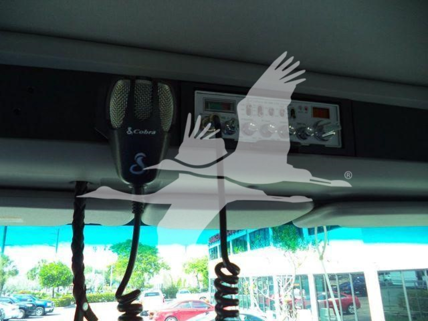 Kenworth T880 cab interior view showing dashboard area with radio/controls and two mounted mics; reflection and windshield visible.
