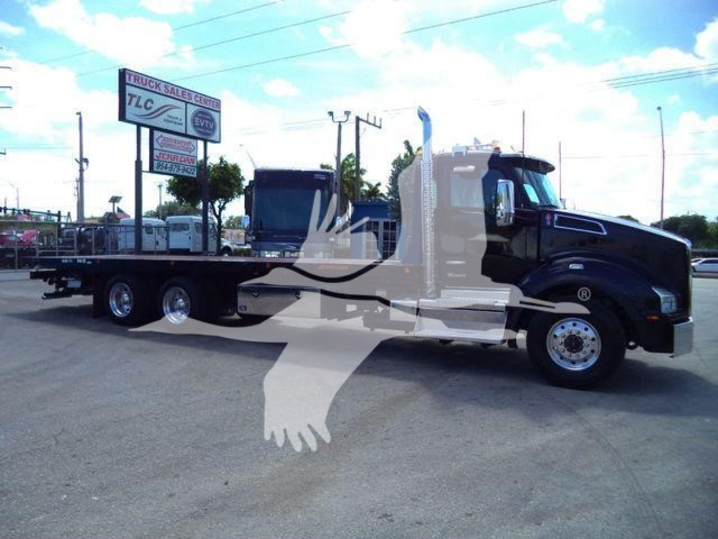 Kenworth T880 rollback truck in profile view showing flatbed, black cab, long hood, dual rear axles, and chrome wheels.