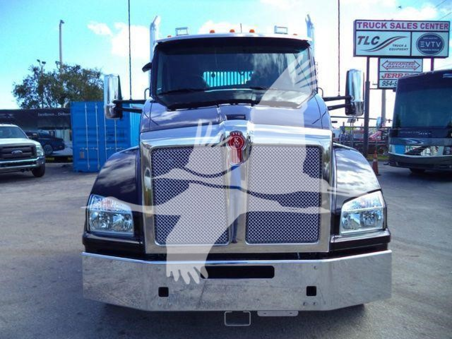 Kenworth T880 cab front view showing large chrome grille, bumper, and emblem; black hood with chrome accents and rectangular headlights.