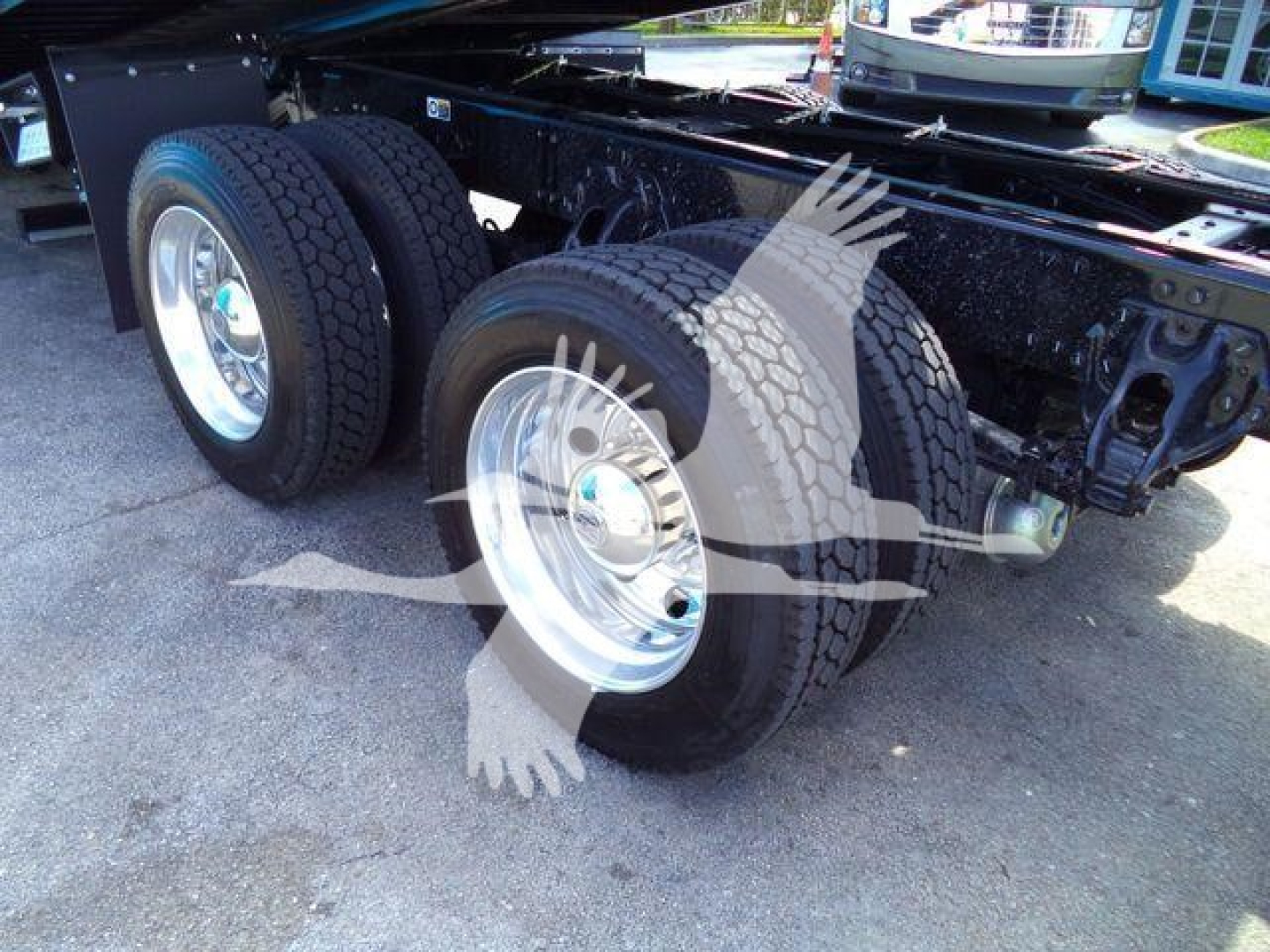 Kenworth T880 rear wheels and chassis showing dual rear axles with large tires and polished rims.