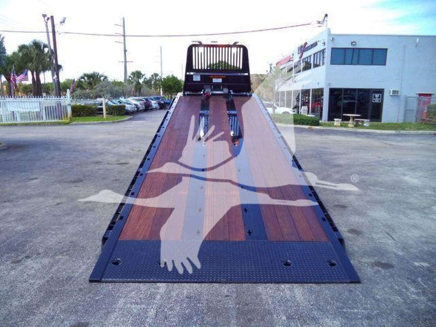 Kenworth T880 rollback bed showing wooden deck and ramp at rear with cabin in distance.
