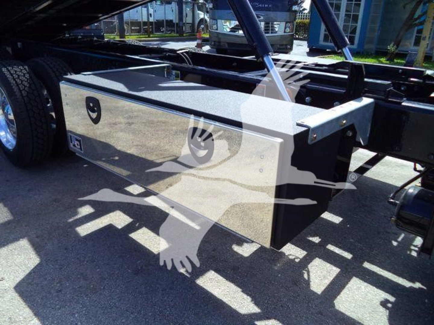 Kenworth T880 rollback truck chassis with storage box and hydraulic components visible under a platform.
