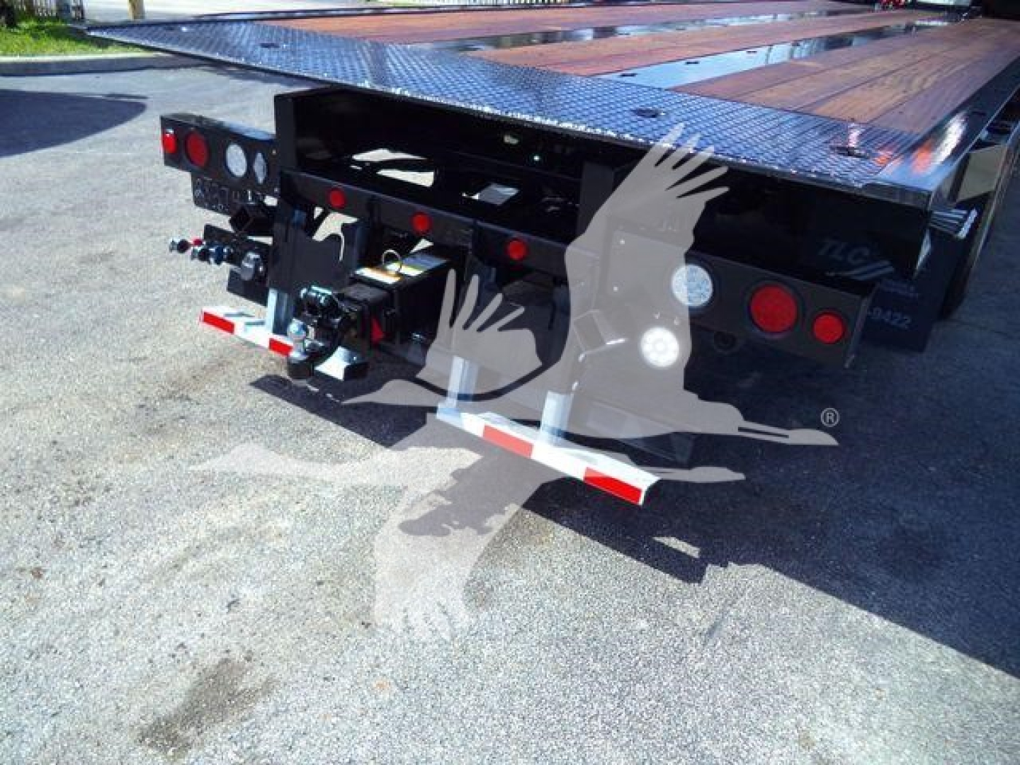 Kenworth T880 rollback trailer rear with docking hitch and taillights visible; platform deck and structural frame in view.