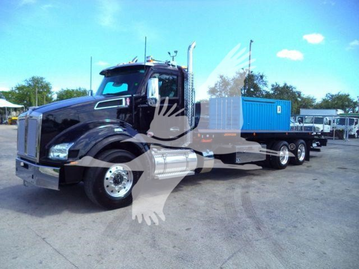 Kenworth T880 rollback truck in black with blue service body and chrome exhaust stacks, front three-axle configuration visible.