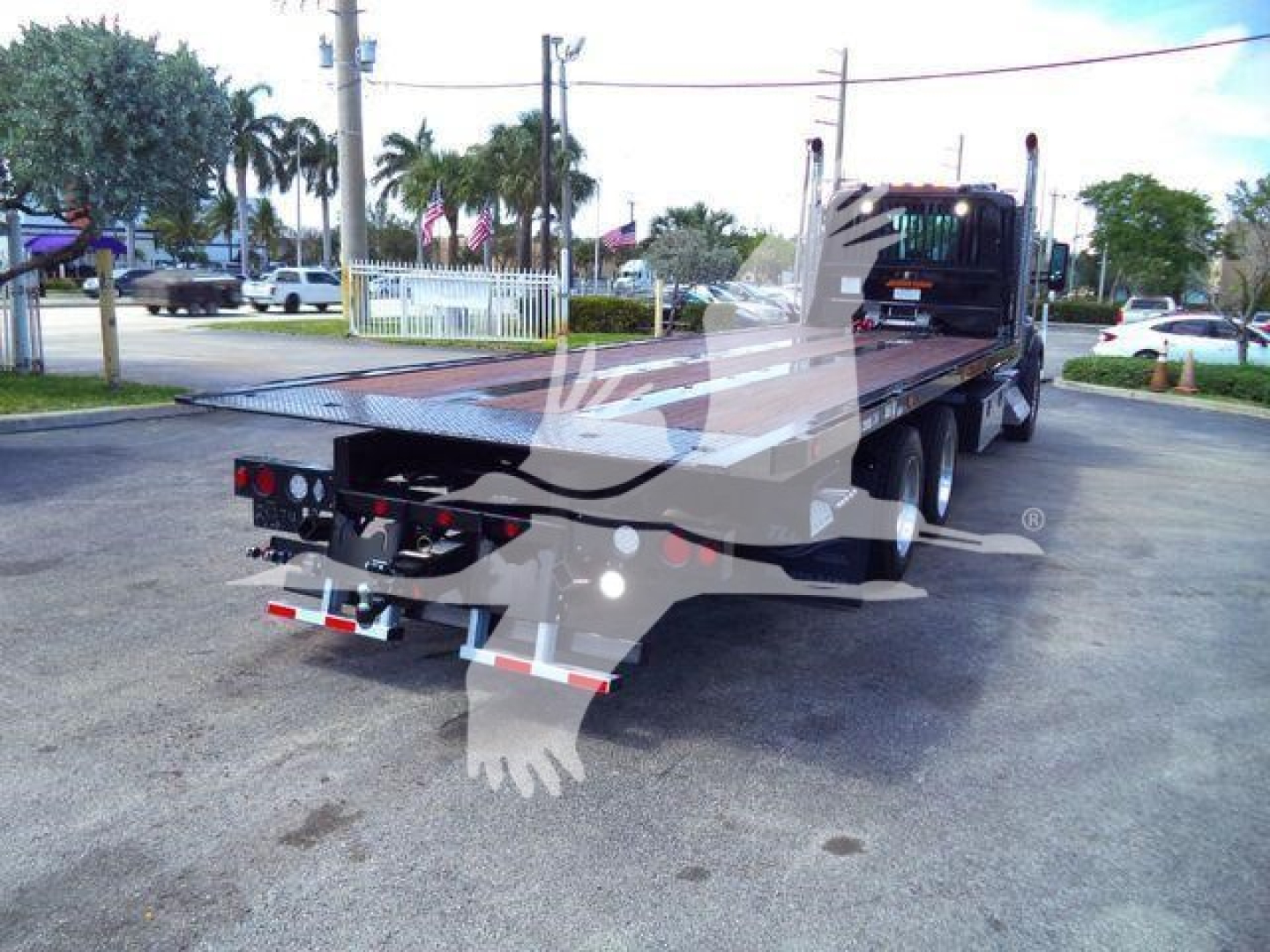 Kenworth T880 rollback truck rear-left view showing flatbed and wheeldug; no legible model text on side visible.