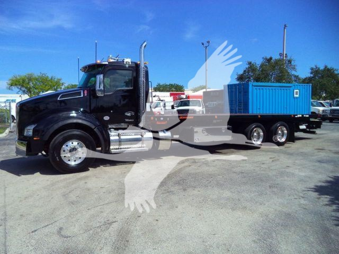 Kenworth T880 rollback truck with a blue container on the flatbed, side view showing cab and wheel configuration.