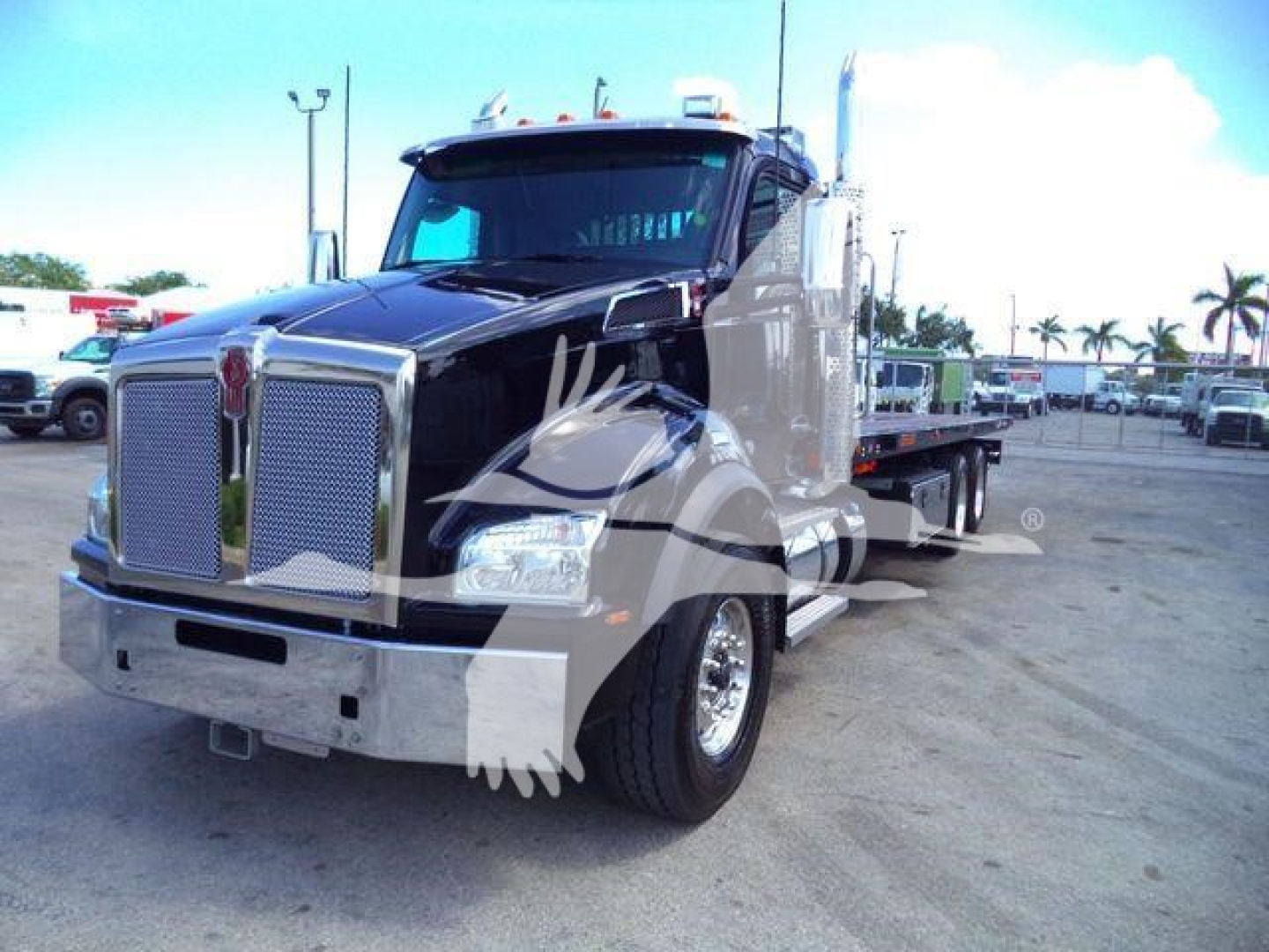 Kenworth T880 rollback truck front-left view showing chrome grille and dual exhaust stacks.