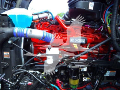 Kenworth T880 engine bay with red engine block labeled X15, various hoses and components visible (no plate).