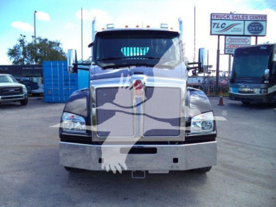 Kenworth T880 front view truck in a dealership lot with stock number J68211, shows chrome grille, headlights, and large bumper.