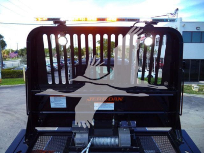 Kenworth T880 rollback truck bed with hydraulic winch and grille, in-service equipment showing JERADAN logo on the gate.