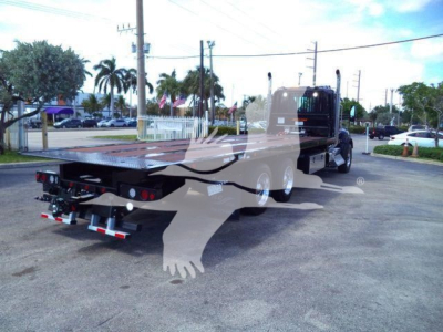 Kenworth T880 rollback truck trailer rear view showing flatbed with hydraulic ramps and dual rear wheels.