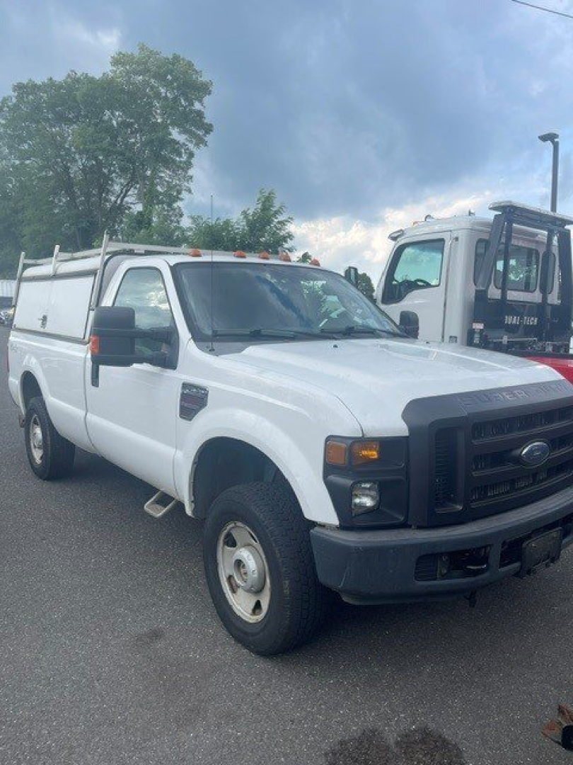 Ford F-250 Super Duty SRW first-gen 2008 white pickup truck with utility body and ladder rack, front grille and headlights visible.