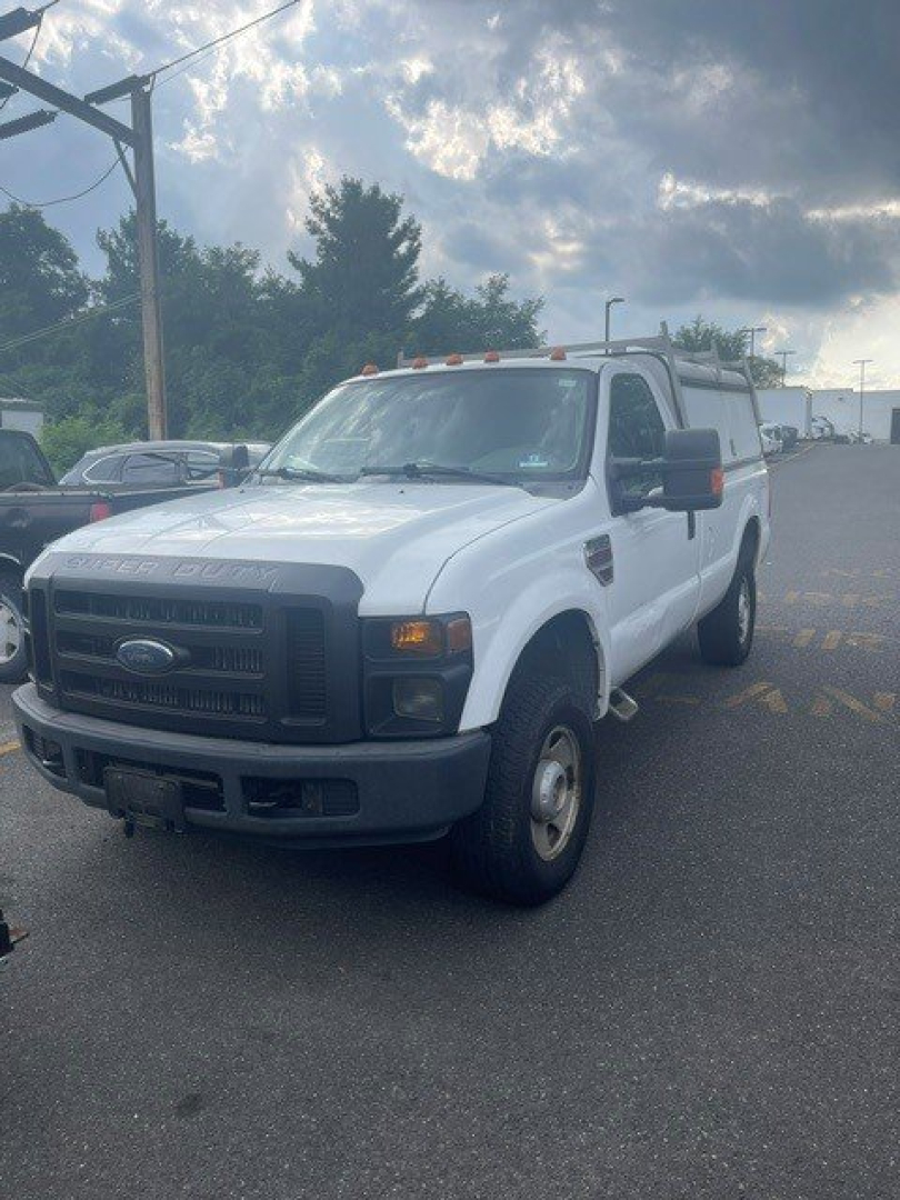 Ford F-250 Super Duty SRW pickup truck white front-left view showing bumper, grille, headlights, and side mirror.