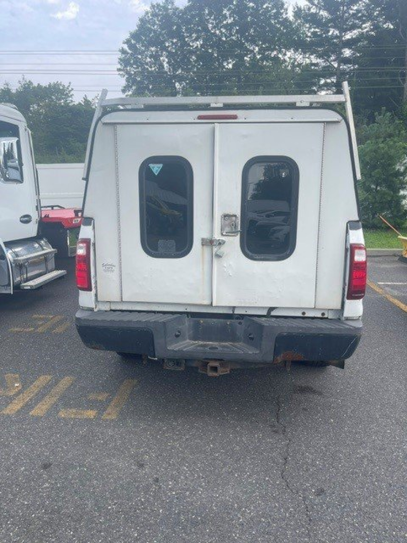 Ford F-250 Super Duty rear view showing dual rear doors and tailgate, white cargo van style rear with bumper and hitch.