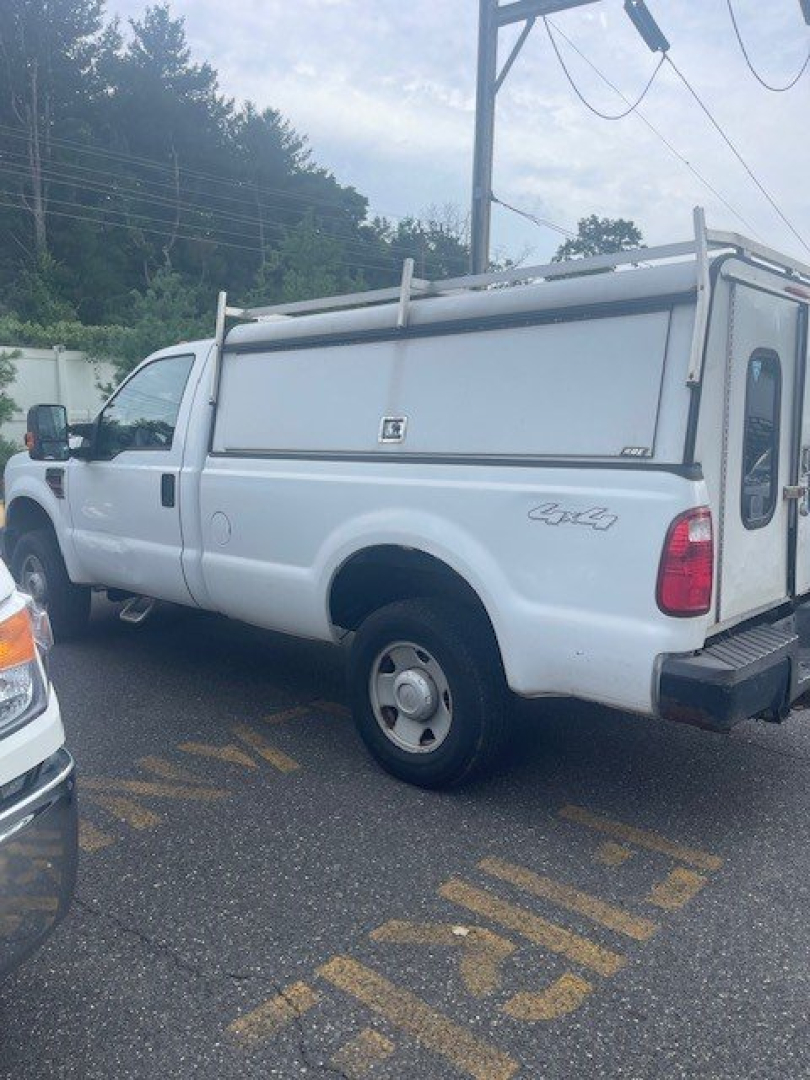 Ford Super Duty F-250 SRW pickup truck with white utility/storage topper, visible rear and side profile, basic equipment, salvage or used condition