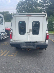 Ford F-250 Super Duty rear view showing dual rear doors and tailgate, white cargo van style rear with bumper and hitch.