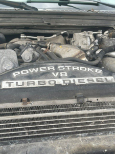 Ford Power Stroke V8 Turbo Diesel engine badge visible under hood showing EGR components and surrounding manifold.