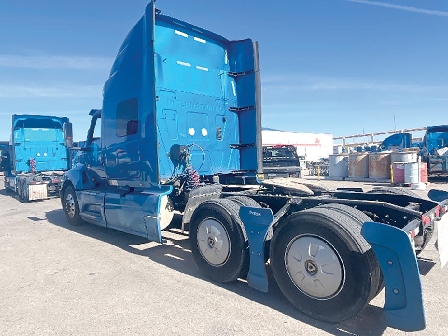 Truck cab and chassis of a 2020 International LT625 with blue paint, three axles, rear sleeper, fuel tanks, and visible wheels.