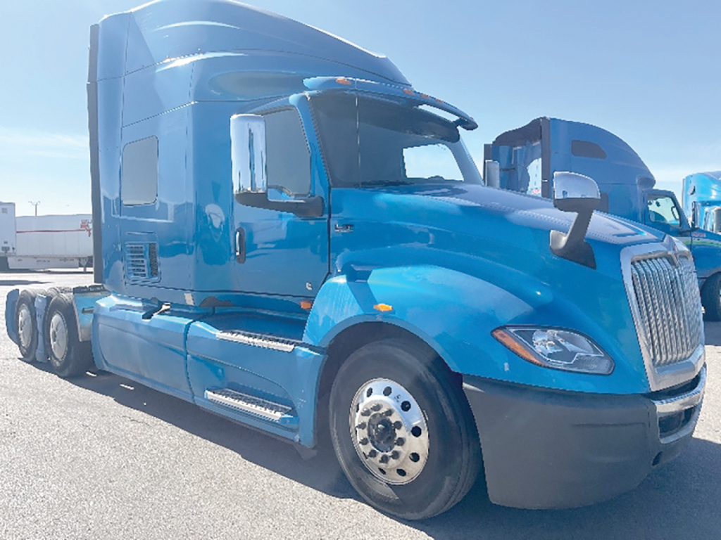Semi truck cab with sleeper showing International LT series styling and blue paint.