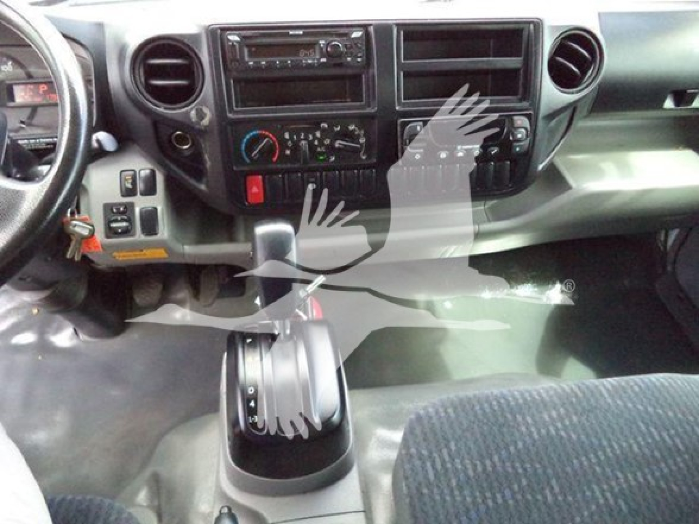 Cab interior of a 2019 Hino 195 refrigerated truck showing dashboard, controls, and gear shift