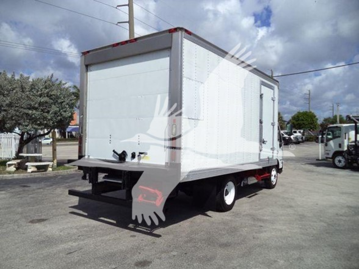 Rear-right side of a white 2019 Hino 195 refrigerated box truck. Visible features: box body, rear bumper with taillight, undercarriage, white wheels. No legible labels or text visible on the vehicle.