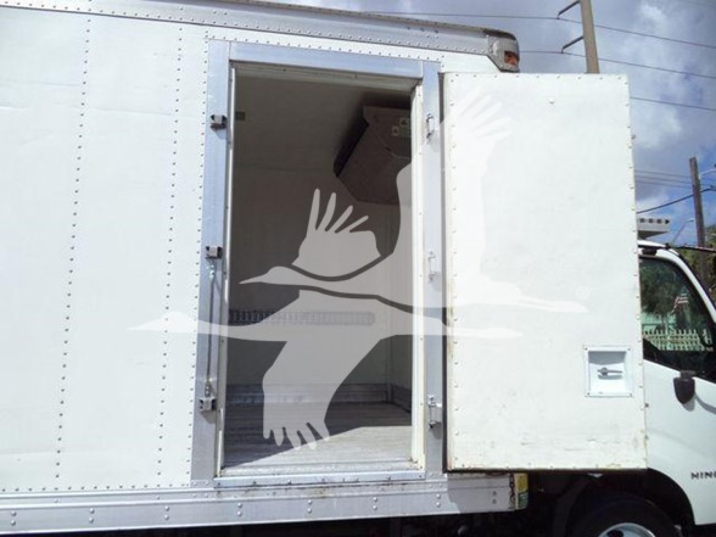 Rear open cargo area of a white refrigerated truck with side door open, showing interior empty box.