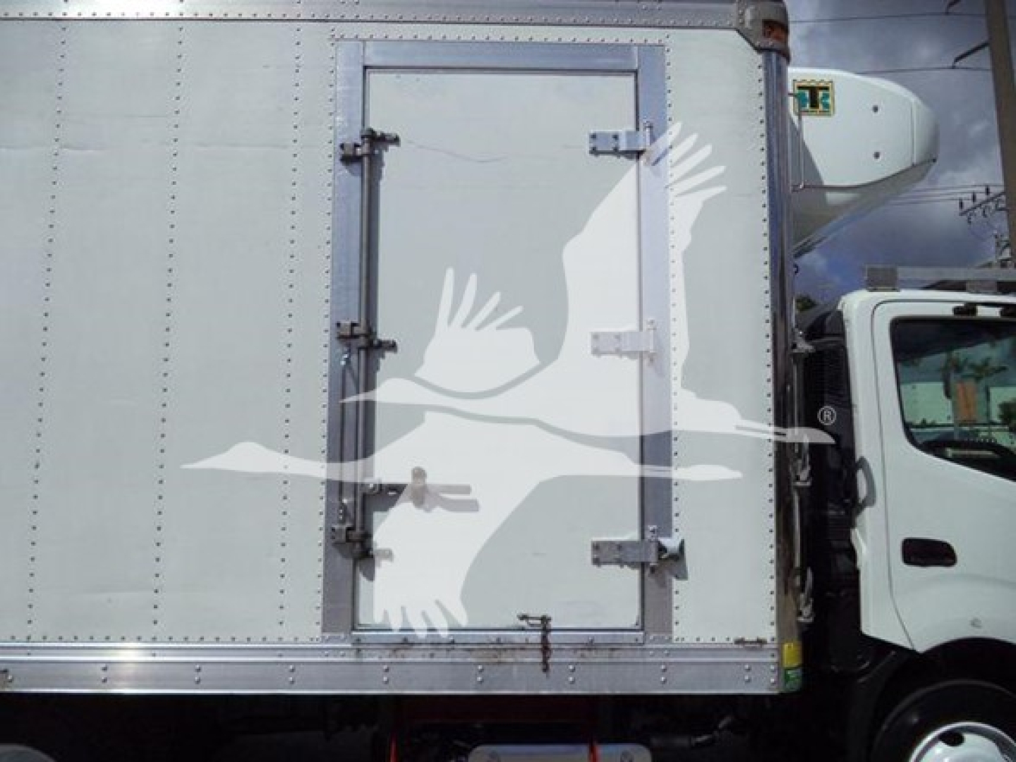 Truck refrigerated body side showing rear access door with latches and hinges