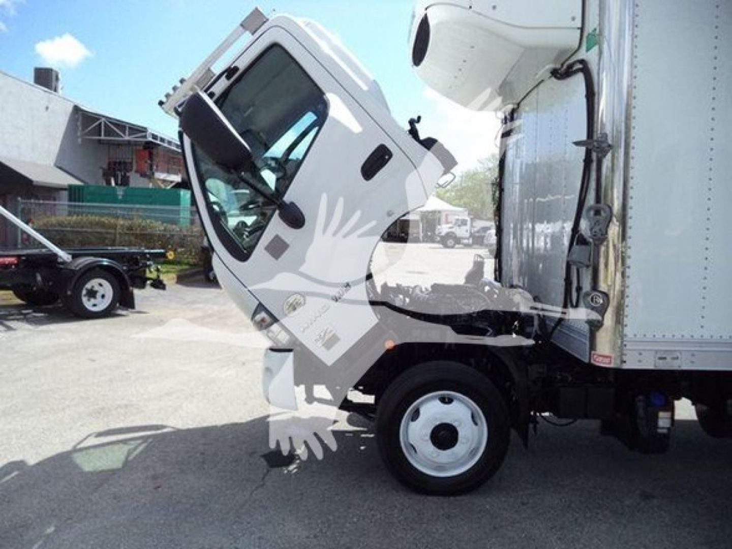 Truck cab of a 2019 Hino 195 in a side-tilt view showing the front wheel and side door of the Cab; refrigeration unit mounted on the cargo area.