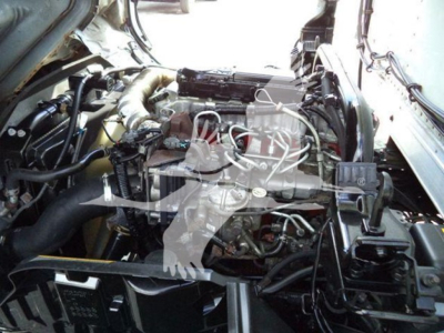 Engine bay view of a 2019 Hino 195 refrigerated truck showing the engine and various hoses and components.