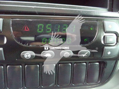 In-dash digital gauge cluster showing green LCD numbers and Thermo King control panel in a refrigerated truck cab.