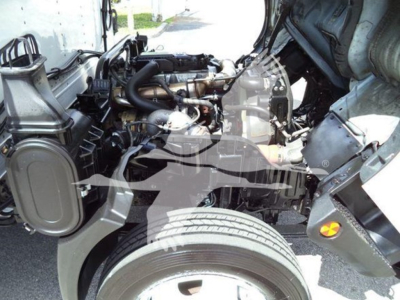 Hino 195 engine bay showing exposed diesel engine components and cooling system with visible radiator and hoses.