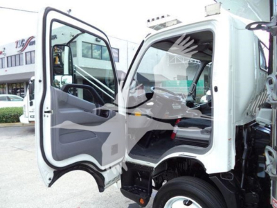 1999 Hino 195 refrigerated truck cab interior and open driver door showing seating and dashboard text faintly visible
