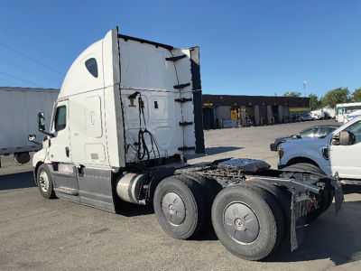 Truck cab and rear chassis of a Freightliner Cascadia126 with sleeper cab, three axles, and fifth-wheel area visible.