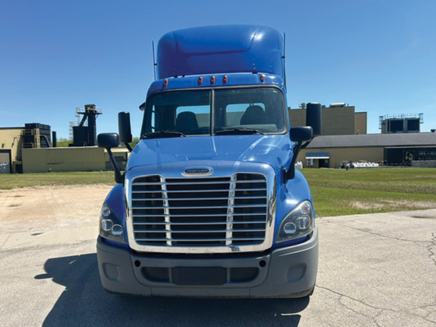 Freightliner Cascadia125 Evolution truck front view showing chrome grille, blue cab, and gray bumper.