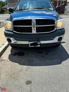 Front view of a blue 2007 Dodge Ram 1500 pickup showing grille with crosshair design, chrome bumper, and headlights.