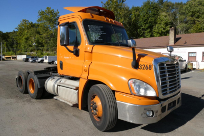 Orange Freightliner Cascadia 125 day cab truck side view showing front grille and cab number 3268.