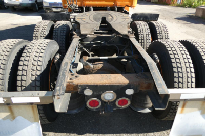 Rear view of a Freightliner Cascadia 125 tractor chassis showing dual rear axles, frame rails, and wiring harnesses with taillight assemblies visible.