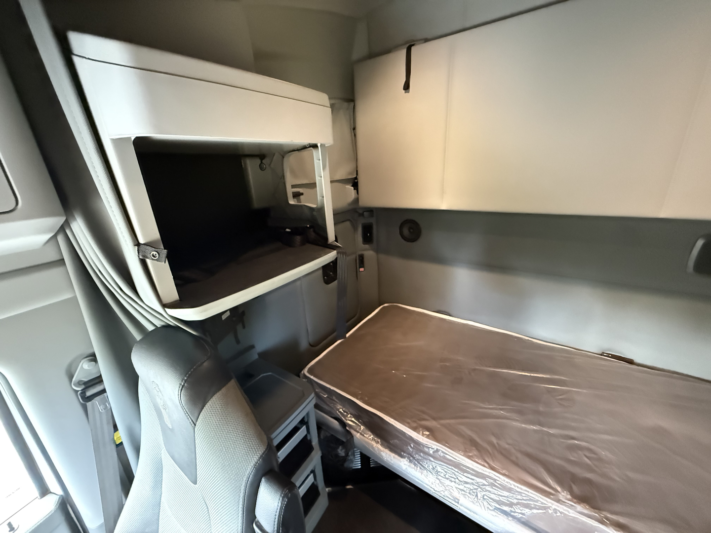 Kenworth T680 truck sleeper cab interior showing bunk bed setup and storage compartments.