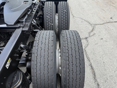 Kenworth T680 chassis with dual rear axles and worn tires, showing suspension and frame components.