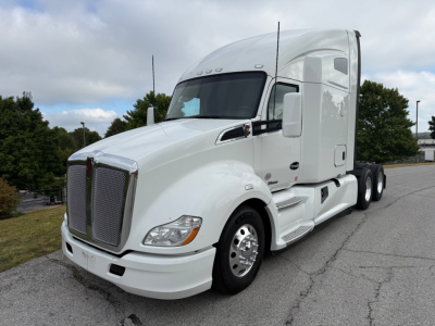 Kenworth T680 tractor-trailer in white, front three-quarter view showing sleeper cab, chrome grille, and side steps.