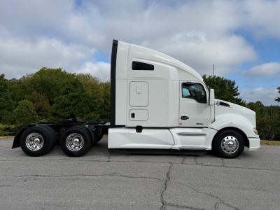 Kenworth T680 tractor side view with white cab and sleeper, fuel tanks, and rear dual axles. The image shows the external profile of a highway tractor.