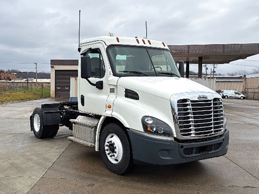 White Freightliner Cascadia 113 daycab truck front-left view with cab and chrome grille, black bumper, dual exhaust, no trailer attached.