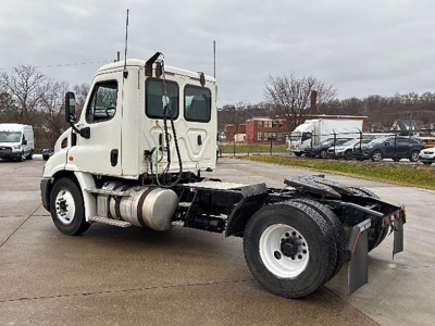 Freightliner Cascadia 113 cab with chassis exposed, white truck, fuel tanks and rear wheels visible, VIN tag not readable.