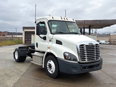 White Freightliner Cascadia 113 daycab truck front-left view with cab and chrome grille, black bumper, dual exhaust, no trailer attached.