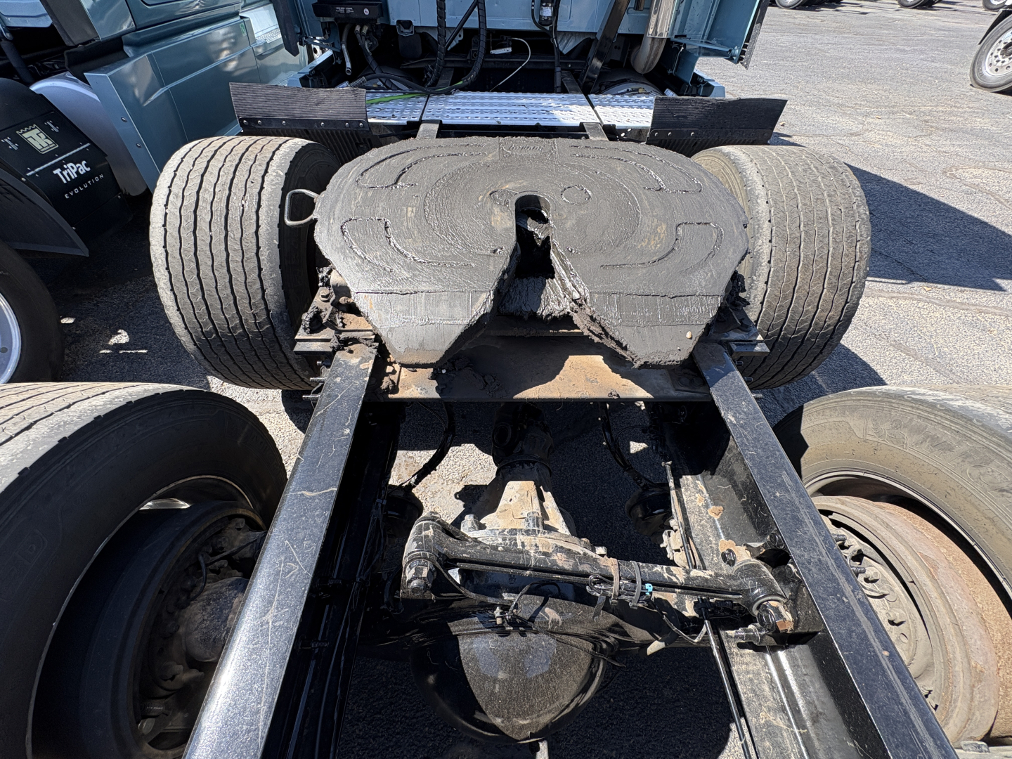 Truck chassis with fifth wheel and dual rear tires, view of the back of a 2022 Volvo VNL64T760 showing the fifth wheel and suspension components.