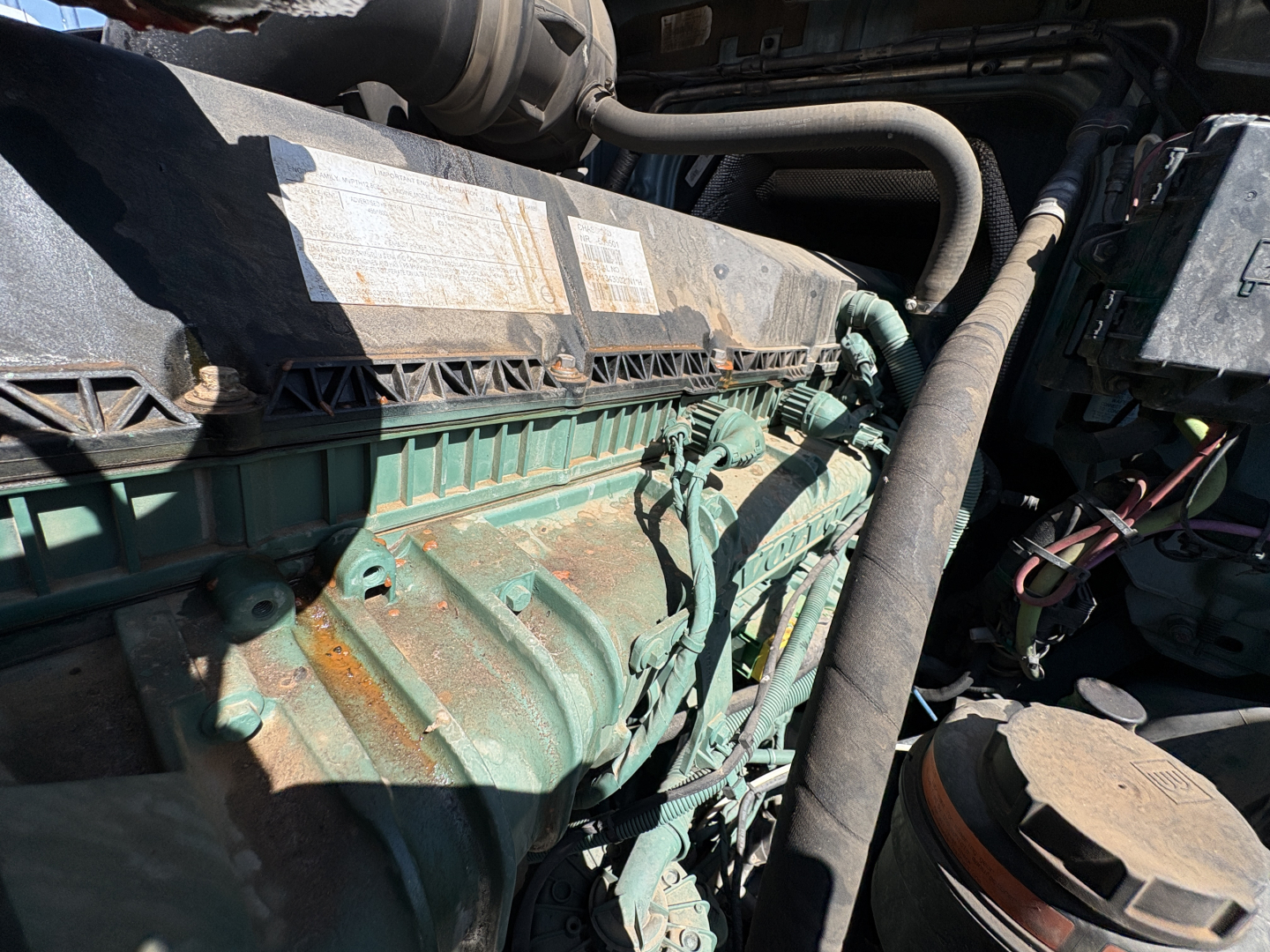Volvo VNL64T760 engine bay showing engine block, hoses, and electrical wiring harnesses.